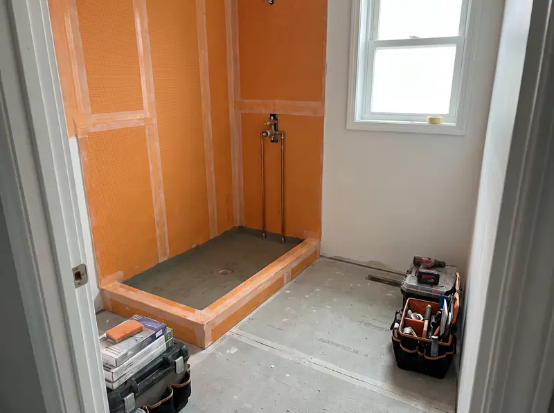 Shower walls sealed with waterproofing membrane before tile