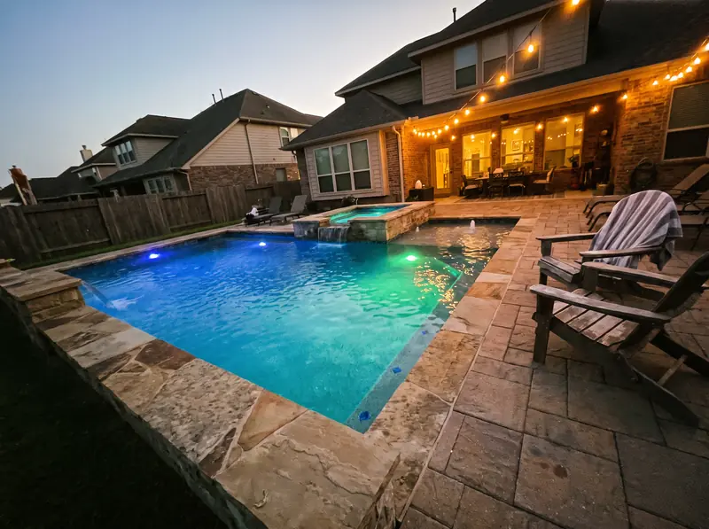Pool and spa with lights on at dusk