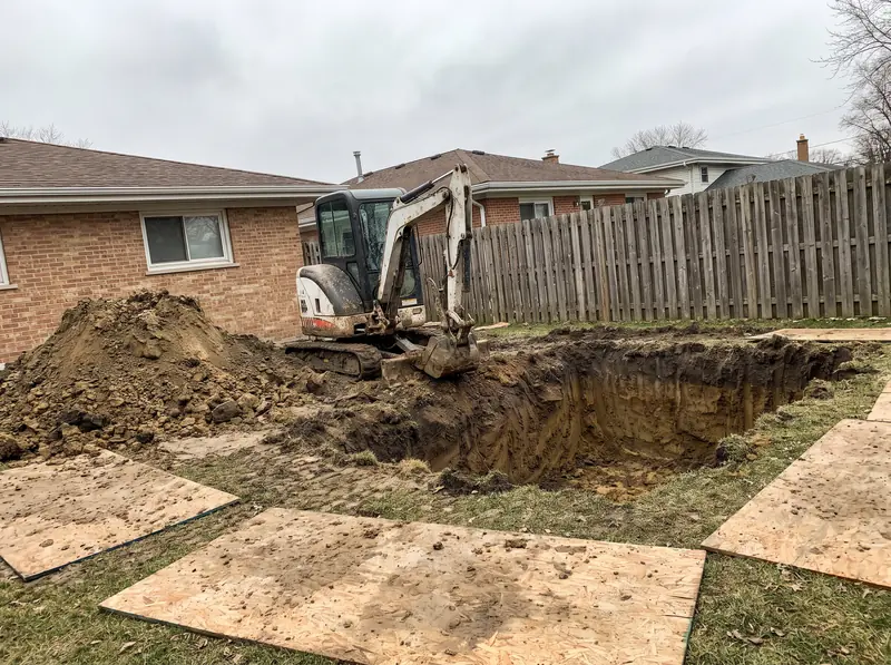 Mini excavator digging an inground pool in a suburban backyard